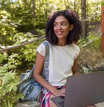 cheerful-african-woman-outdoors-sitting-ladder